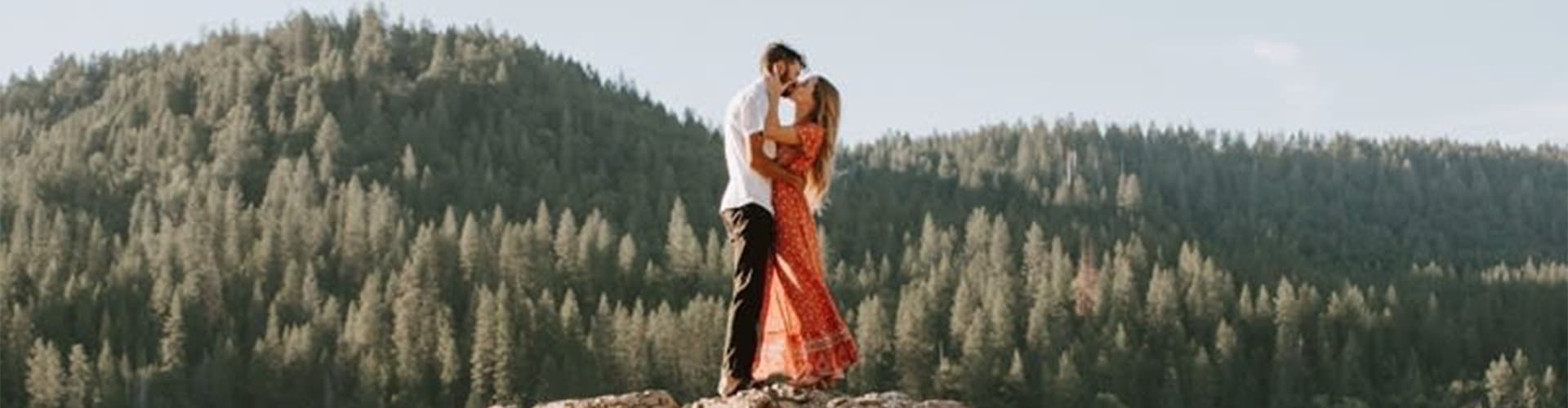 What to wear for mountain engagement photos — couple walking on mountain overlook
